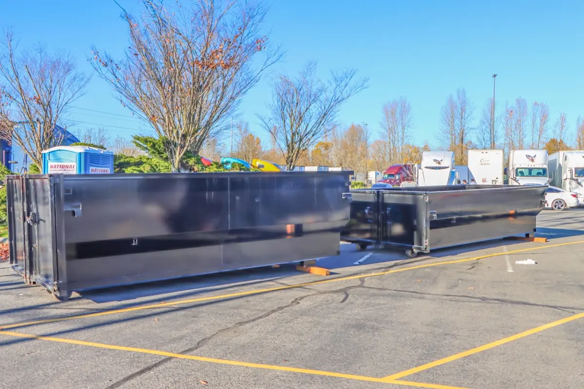 Professional dumpster rental service with roll-off container on residential driveway in Brookline